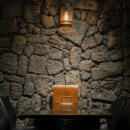 暖かな灯りに照らされた石壁と小さな席が落ち着いた雰囲気を作る。