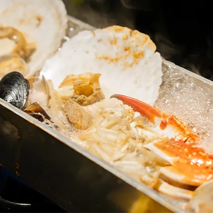 カニやホタテなど多彩な海鮮が蒸し上がり湯気とともに盛り付けられています。