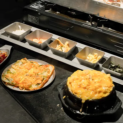 チヂミや卵料理と小皿の韓国おかずが食卓に並び温かい雰囲気を作っています。