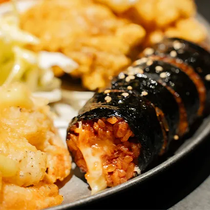 チーズ入りのキムチキンパが切られ、揚げ物と一緒に皿に盛られています。