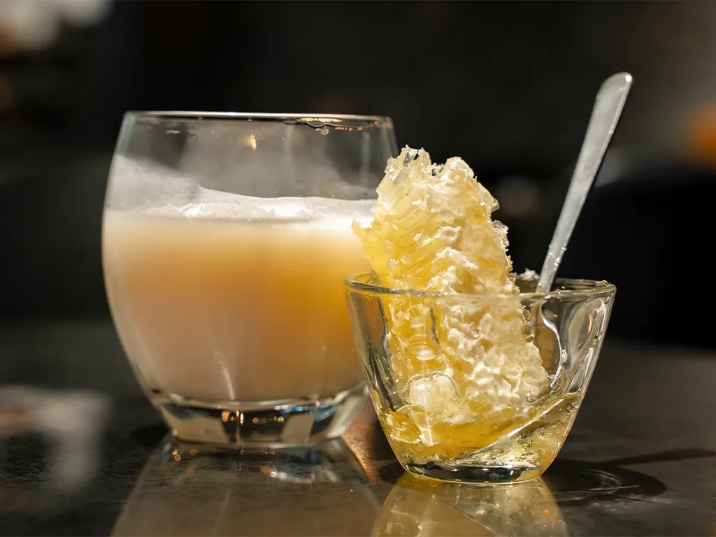 マッコリと蜂の巣のハチミツがグラスに入れられている